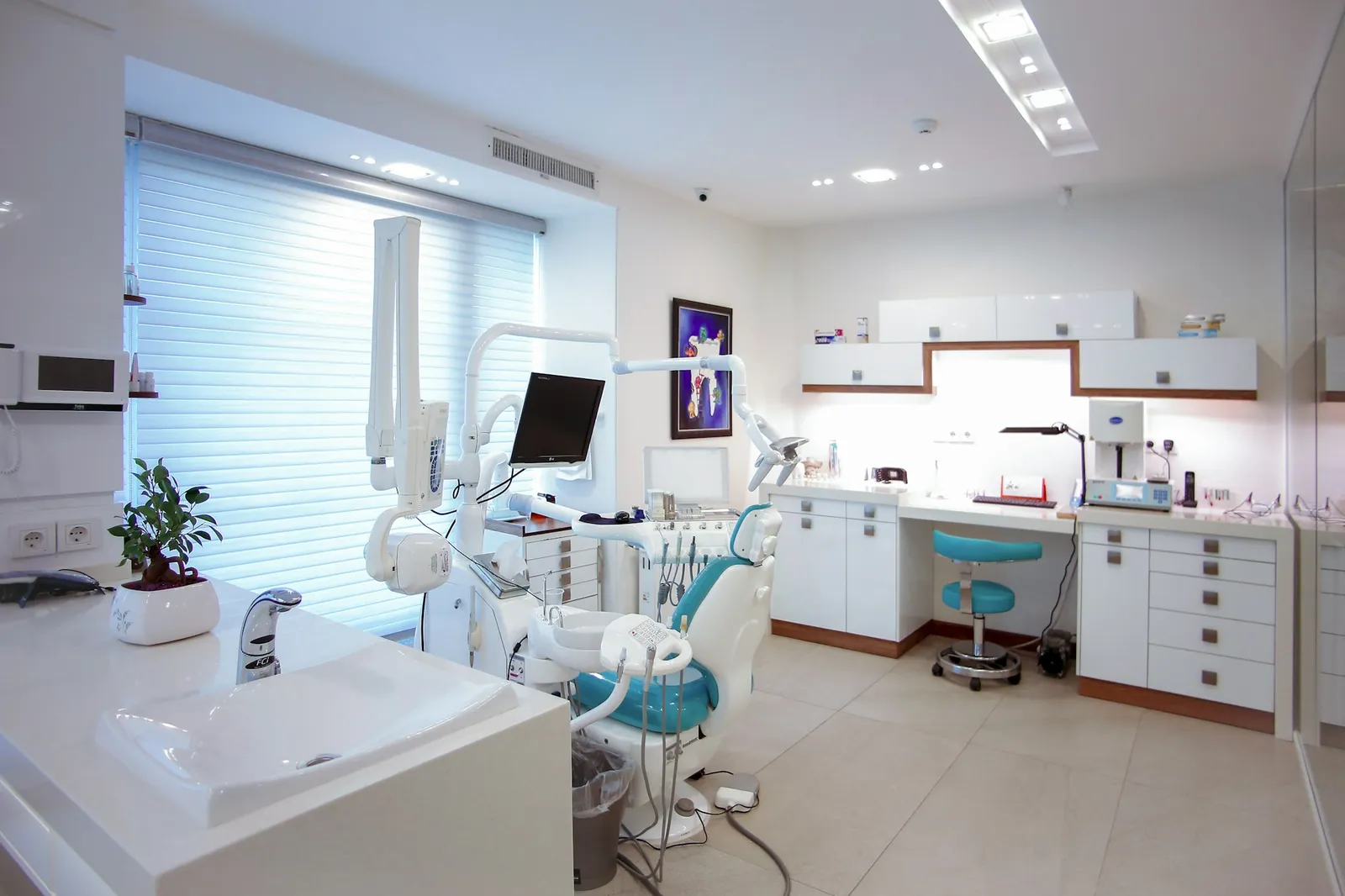 Muayene koltuğu ve dental ünitesiyle hazır bekleyen modern bir diş kliniği odası