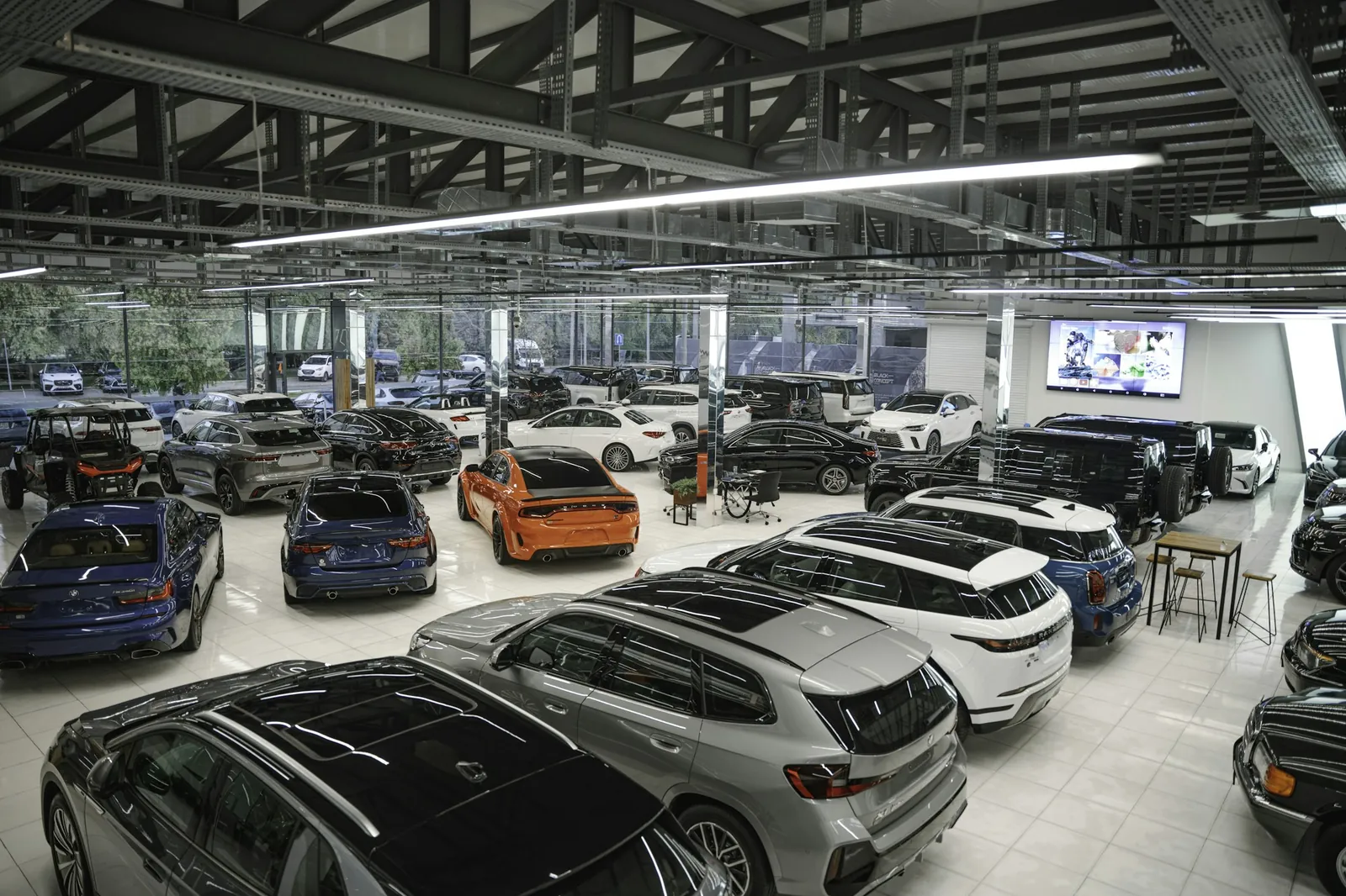 Kapalı bir galeri alanında sıra hâlinde sergilenen otomobiller