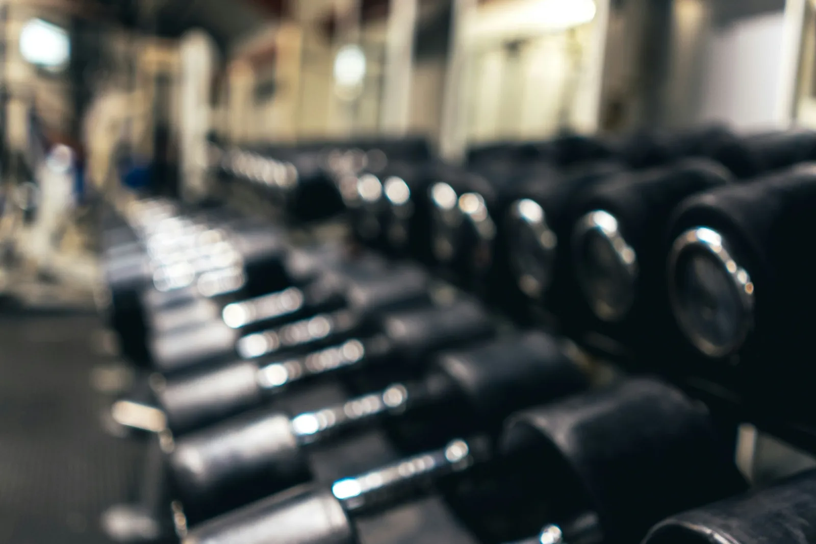 Spor salonunda standa ağırlık sırasına göre dizilmiş siyah dambıl takımı